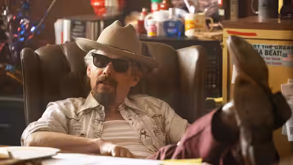 Lee Raybon (Ethan Hawke) sits behind a desk as someone faces him