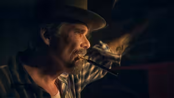 Lee Raybon (Ethan Hawke) smokes a cigar in a dimly lit room