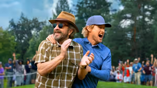 Pryce Cahill (Owen Wilson) and Santi (Peter Dager) laugh together at a golf course