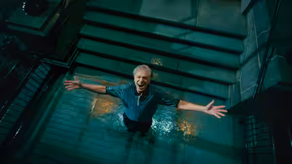 Happy Gilmore (Adam Sandler) spreads his arms while standing in a flooded stairwell