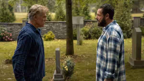 Happy Gilmore (Adam Sandler) faces an older man outside among gravestones
