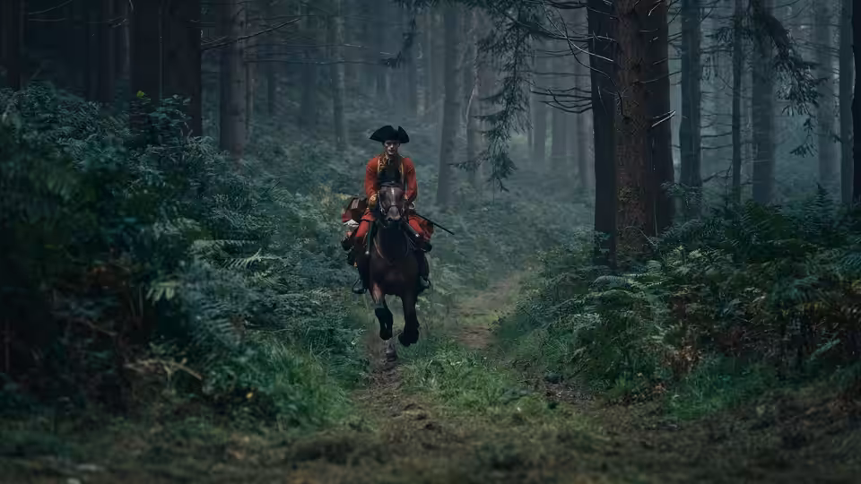 George Washington (William Franklyn-Miller) rides a horse along a forest path