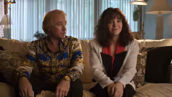 Christy Martin (Sydney Sweeney) sits beside Jim Martin (Ben Foster) on a living-room couch