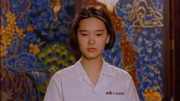 Ming (Lisa Yang) faces forward in her school uniform before a painted mural