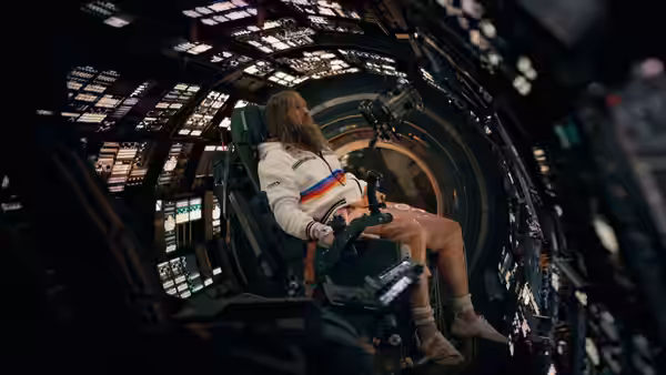 A woman seated in the command chair of a spaceship bridge