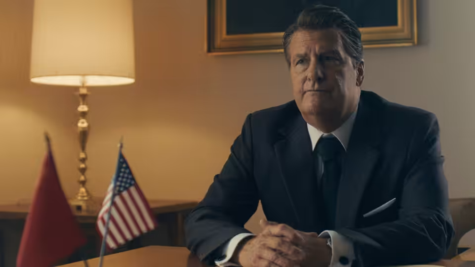 Ronald Reagan (Jeff Daniels) sits at a desk beside American and Soviet flags