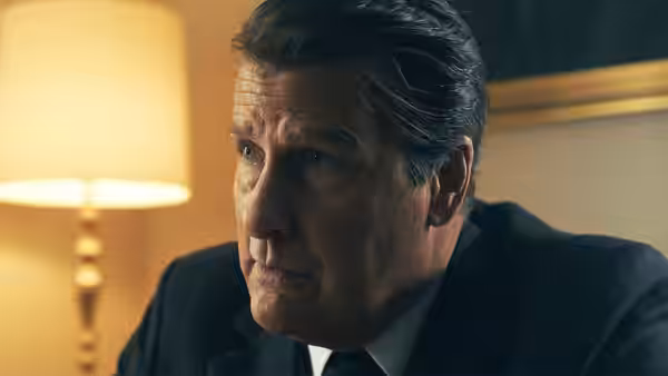 Ronald Reagan (Jeff Daniels) leans forward at his desk