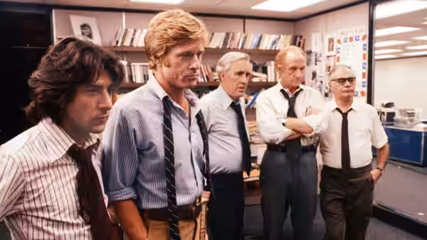 Carl Bernstein and Bob Woodward stand with three colleagues in the newsroom