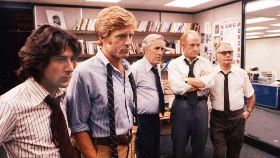 Carl Bernstein and Bob Woodward stand with three colleagues in the newsroom