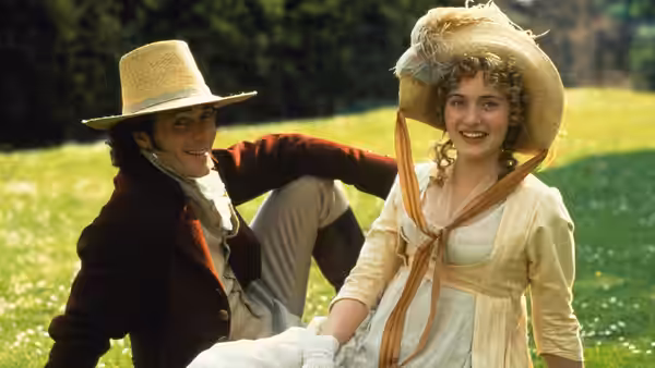 John Willoughby (Greg Wise) reclining beside Marianne Dashwood (Kate Winslet) on a grassy slope