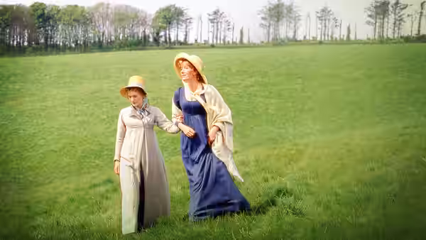 Elinor Dashwood (Emma Thompson) walking with Marianne Dashwood (Kate Winslet) across a meadow