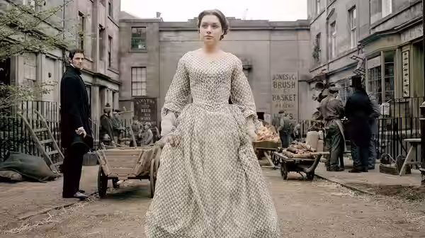 Margaret Hale (Daniela Denby-Ashe) walks through a busy market street with John Thornton (Richard Armitage) behind
