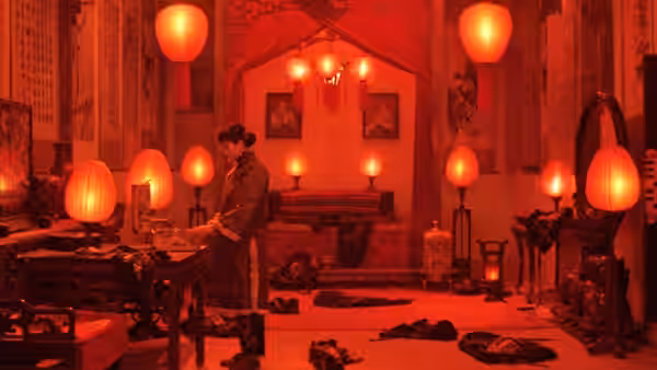 a man standing in a room filled with red paper lanterns