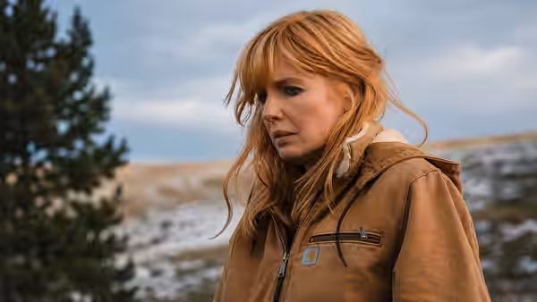 Beth Dutton (Kelly Reilly) stands in a brown jacket beside a snowy landscape
