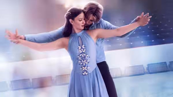 A dark-haired skater extends her arms as her partner guides her on the ice