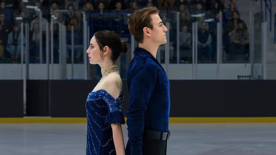Katarina Baker (Kaya Scodelario) and Justin Davis (Evan Roderick) stand back to back on the rink