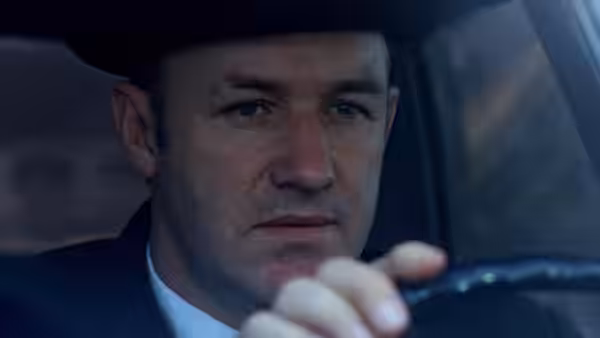 Popeye Doyle (Gene Hackman) gripping the wheel while driving a car