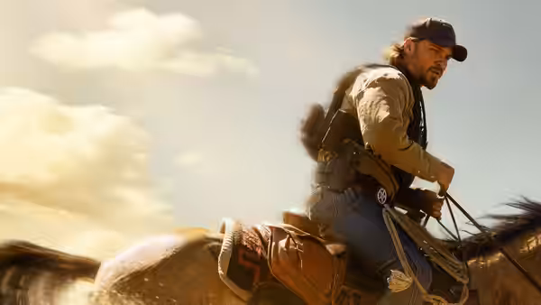 Kayce Dutton (Luke Grimes) rides horseback across open country