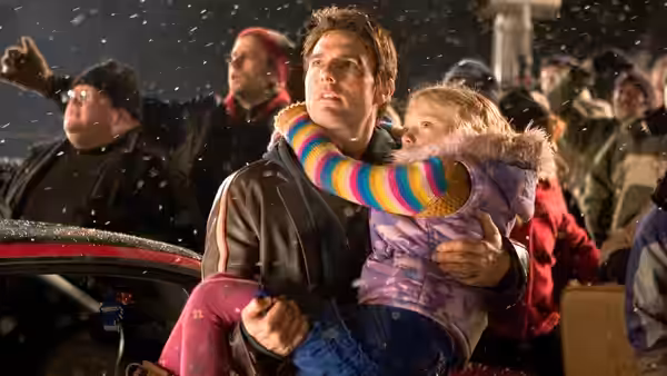 Ray (Tom Cruise) carries Rachel (Dakota Fanning) through a crowded evacuation point