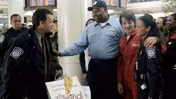 Viktor Navorski (Tom Hanks) greets airport workers and security officers in the terminal