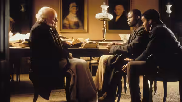 John Quincy Adams (Anthony Hopkins) sits facing two men across a table