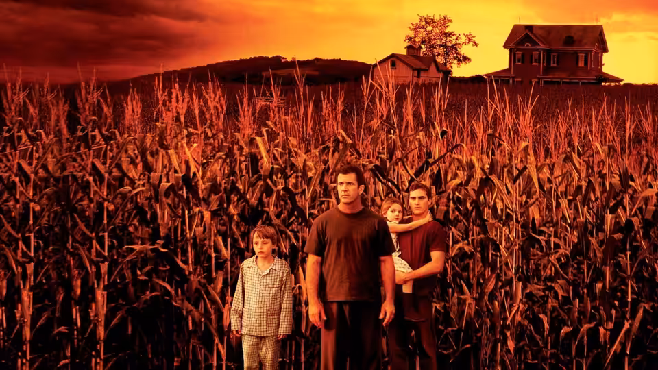 Graham and Merrill Hess stand with Morgan and Bo among corn rows at dusk