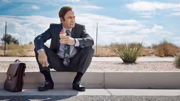 Jimmy McGill (Bob Odenkirk) eats ice cream while seated on a curb