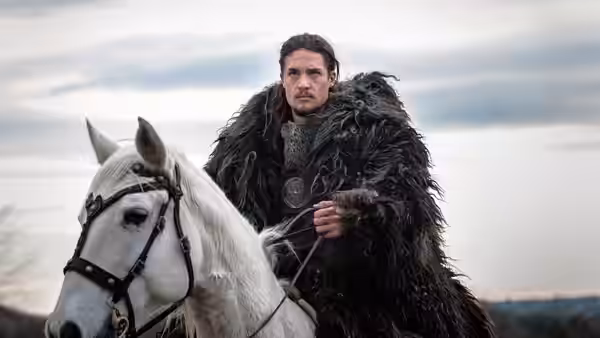 Uhtred of Bebbanburg (Alexander Dreymon) rides a white horse across an open landscape