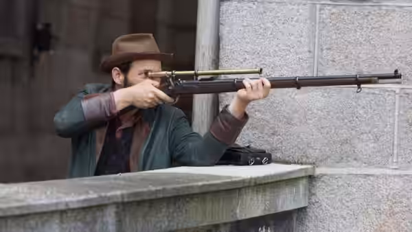 Homer Jackson (Adam Rothenberg) aims a rifle from behind a stone parapet