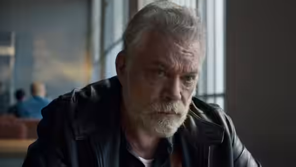 James Big Jim Keene (Ray Liotta) leans forward in a room with prison windows