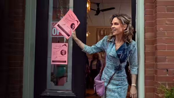 Sharon Stevens (Hilary Swank) holds up a pink flyer outside a storefront