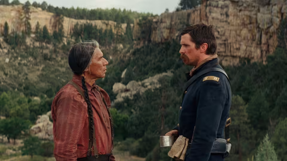 Chief Yellow Hawk (Wes Studi) faces Captain Joseph J. Blocker (Christian Bale) outside a stone building