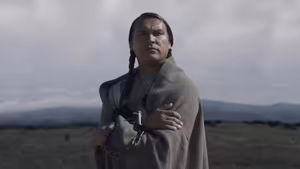 Chief Yellow Hawk (Wes Studi) stands wrapped in a blanket on an open plain