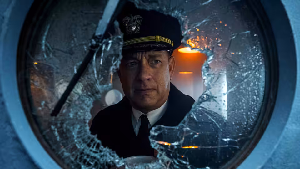 Commander Krause (Tom Hanks) peers through a rain-streaked window on the ship’s bridge
