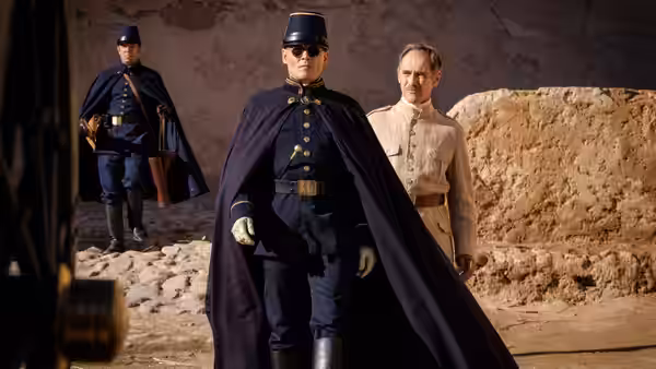 Colonel Joll (Johnny Depp) walks beside the Magistrate (Mark Rylance) through a ruined settlement