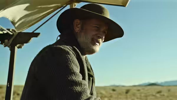 Captain Jefferson Kyle Kidd sits beneath a wagon canopy overlooking open prairie
