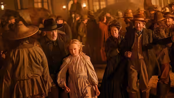 Captain Jefferson Kyle Kidd stands beside Johanna among townspeople gathered indoors