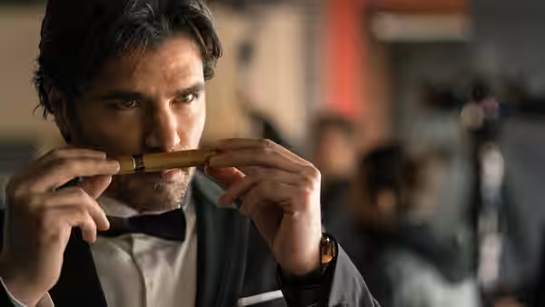 Tim Ballard (Jim Caviezel), dressed in a suit, examines a small object indoors