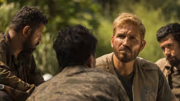 Tim Ballard (Jim Caviezel) listens to men gathered around him outdoors