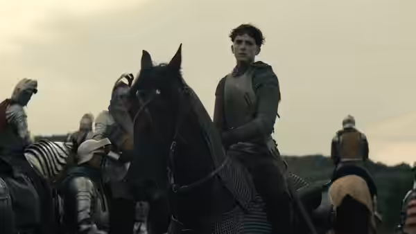 Hal (Timothée Chalamet) rides among mounted soldiers across an open field