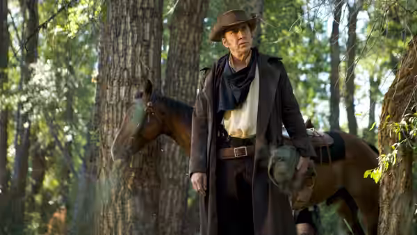 Colton Briggs (Nicolas Cage) stands beside his horse among trees