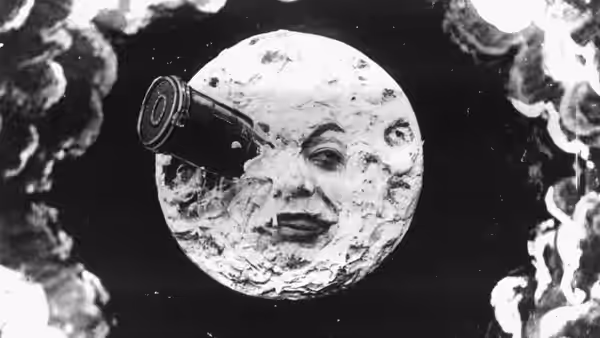 A human-faced moon peers through clouds as a rocket approaches its eye