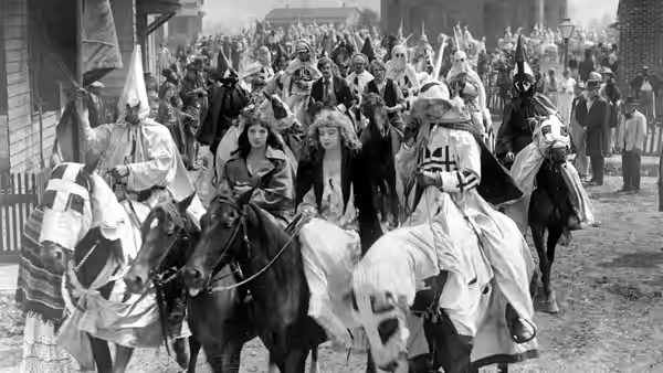 Elsie Stoneman and Margaret Cameron ride through town amid a Ku Klux Klan procession
