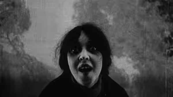A terrified woman stares ahead against a cloudy backdrop
