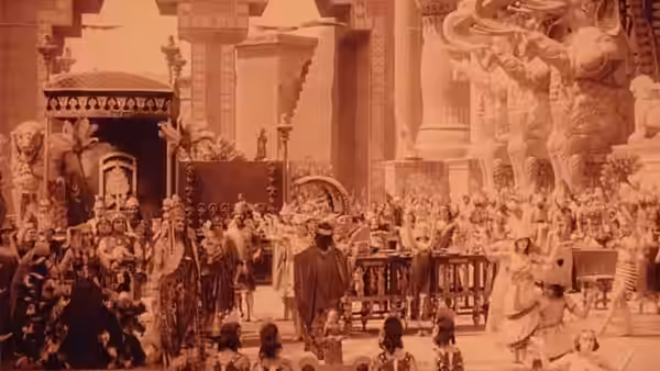 A congregation gathers inside an ornate church beneath towering statues and columns