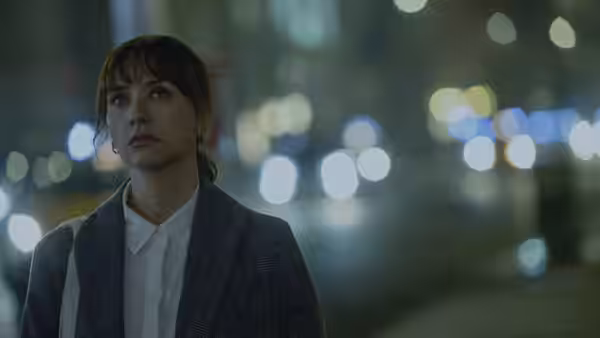 Laura (Rashida Jones) stands beneath blurred city lights