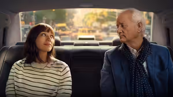 Laura (Rashida Jones) and Felix (Bill Murray) sit together in the back of a car