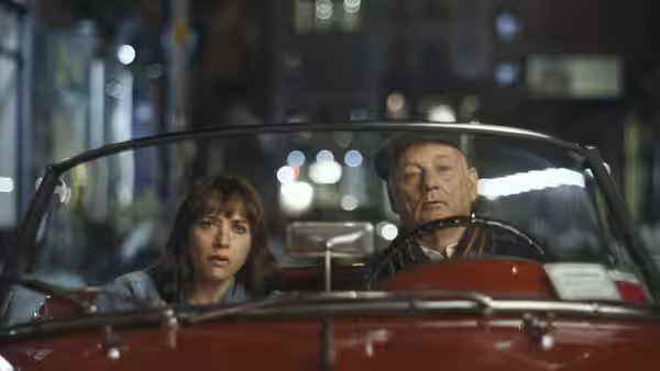 Laura (Rashida Jones) rides beside Felix (Bill Murray) as he drives a red convertible