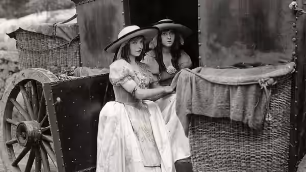 Henriette and Louise shelter beside a covered basket near a cart