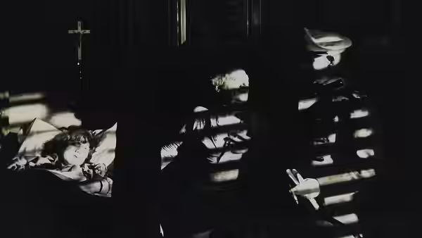 A shadowy figure sits at a piano in a dark room